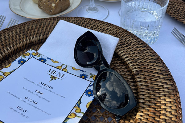 Black sunglasses on a table matt next to a menu